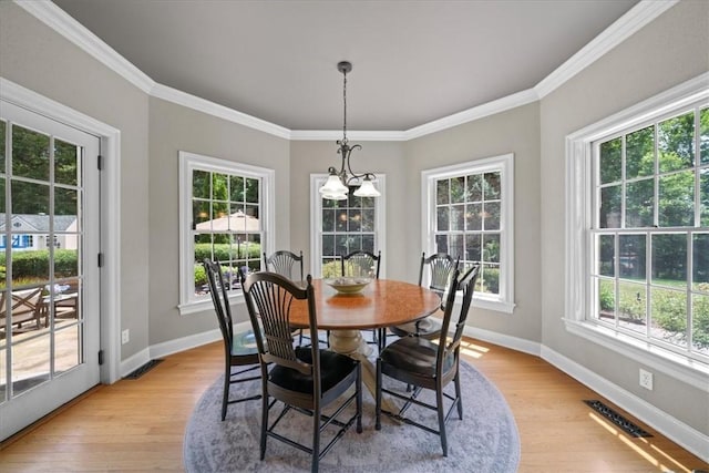 dining area featuring a healthy amount of sunlight, light hardwood / wood-style floors, and ornamental molding