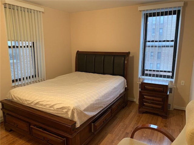 bedroom with radiator and hardwood / wood-style floors