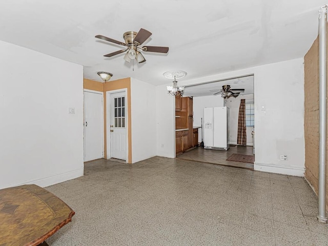 unfurnished living room featuring ceiling fan with notable chandelier