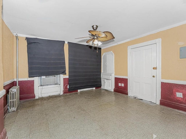 unfurnished room with radiator heating unit, ceiling fan, and crown molding