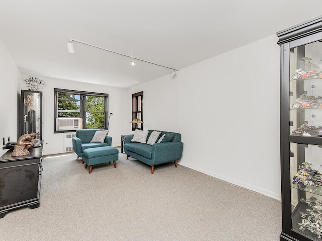 sitting room with carpet floors, rail lighting, and radiator