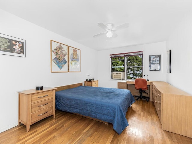 bedroom featuring ceiling fan, light hardwood / wood-style floors, and cooling unit