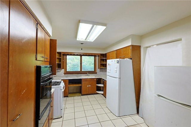 kitchen featuring white appliances, sink, and light tile patterned floors