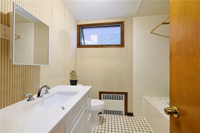 full bathroom featuring vanity, tiled shower / bath, tile patterned flooring, toilet, and radiator heating unit