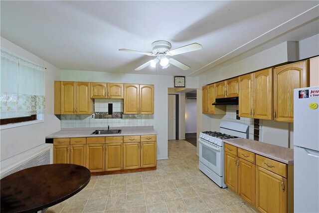 kitchen featuring backsplash, ceiling fan, sink, and white appliances