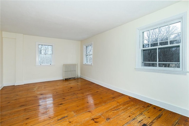 spare room featuring radiator and hardwood / wood-style floors