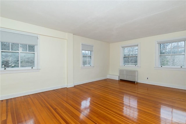 empty room featuring radiator heating unit and wood-type flooring