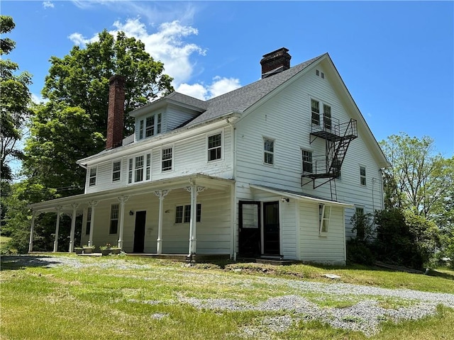 back of property with a porch and a lawn