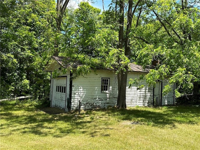 view of outdoor structure featuring a garage and a lawn