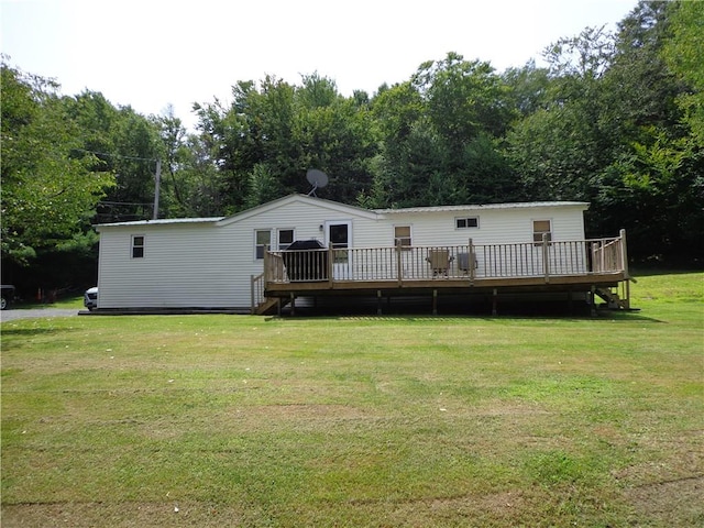 back of house featuring a lawn and a wooden deck