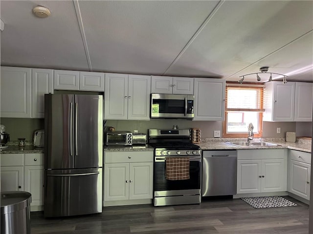 kitchen featuring sink, dark hardwood / wood-style floors, light stone countertops, white cabinetry, and stainless steel appliances