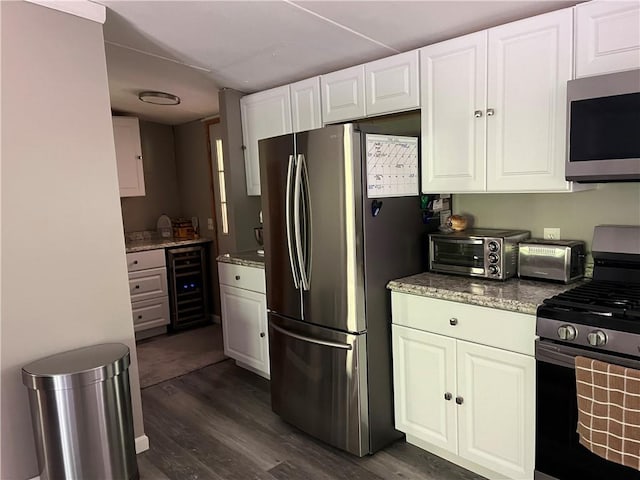 kitchen featuring white cabinets, dark hardwood / wood-style floors, beverage cooler, and appliances with stainless steel finishes