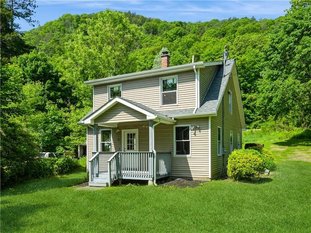 rear view of property with a lawn and covered porch