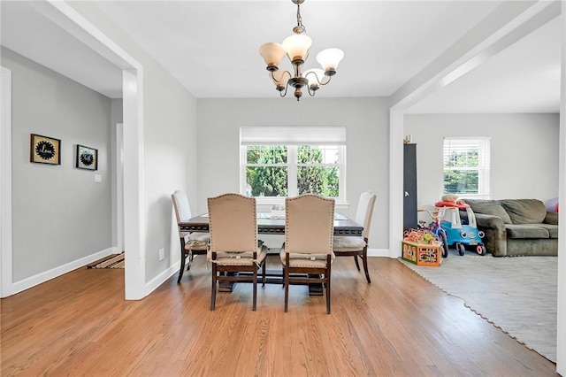 dining area featuring plenty of natural light, an inviting chandelier, and light hardwood / wood-style flooring