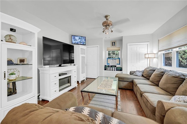 living room with ceiling fan, dark hardwood / wood-style flooring, built in features, and a wealth of natural light