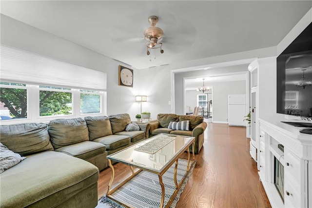 living room featuring hardwood / wood-style flooring and ceiling fan with notable chandelier