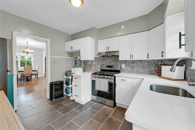 kitchen with white cabinetry, sink, dark wood-type flooring, stainless steel appliances, and a notable chandelier