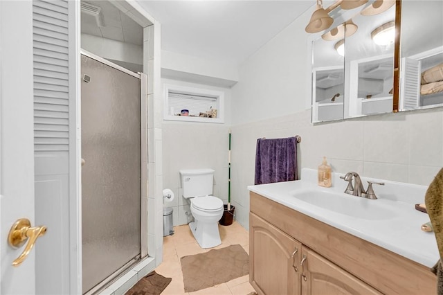 bathroom featuring walk in shower, vanity, tile walls, tile patterned flooring, and toilet