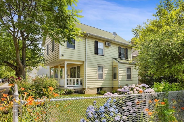 view of front of home with a porch and an AC wall unit