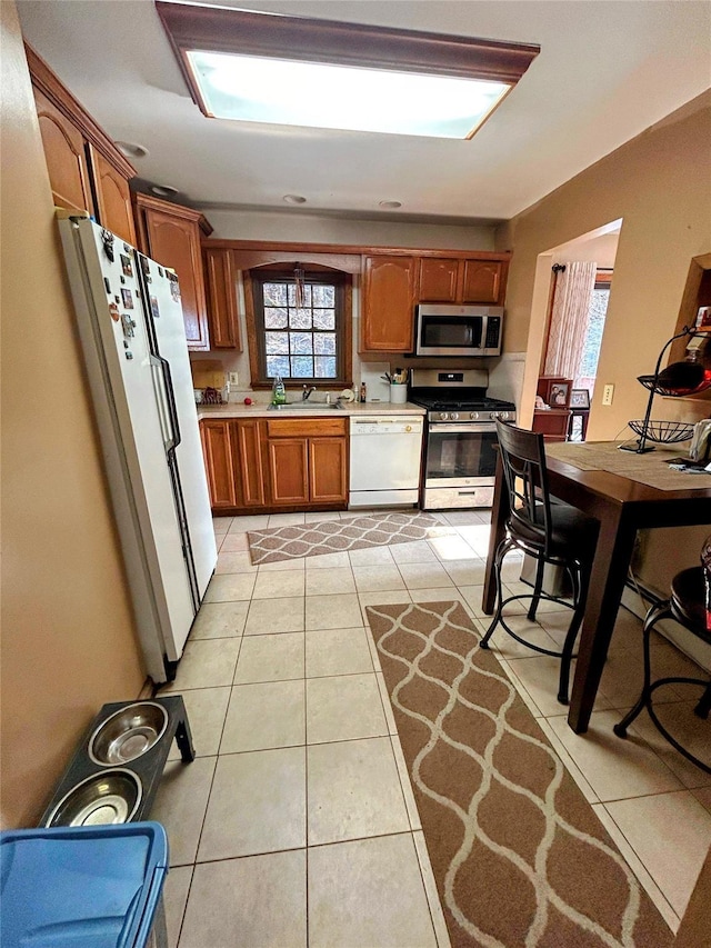 kitchen featuring light tile patterned floors, stainless steel appliances, and a healthy amount of sunlight