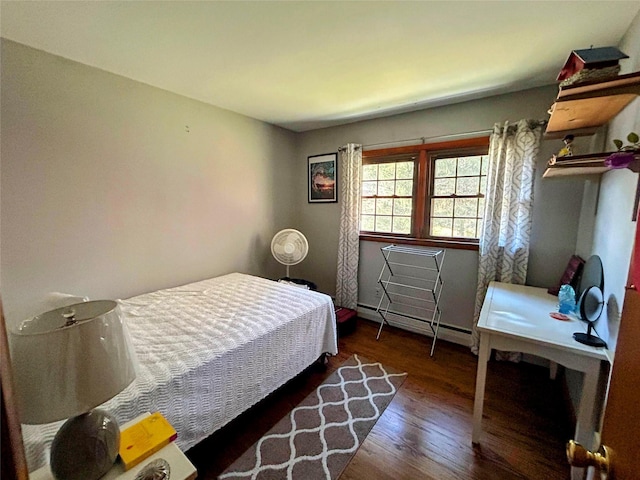 bedroom with dark hardwood / wood-style floors and a baseboard radiator