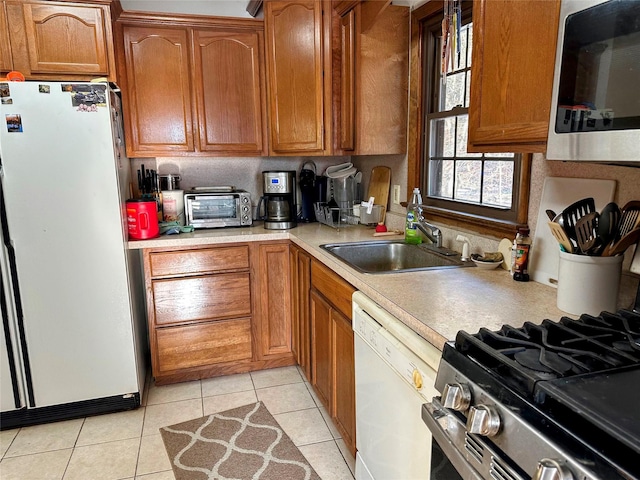 kitchen featuring sink, light tile patterned floors, and stainless steel appliances