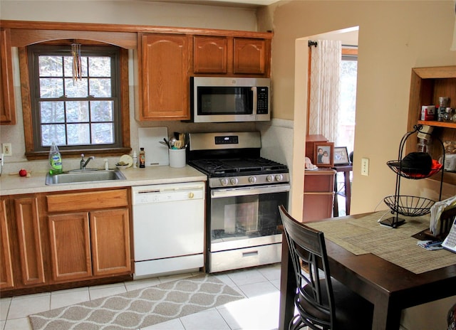 kitchen with sink, light tile patterned floors, and stainless steel appliances