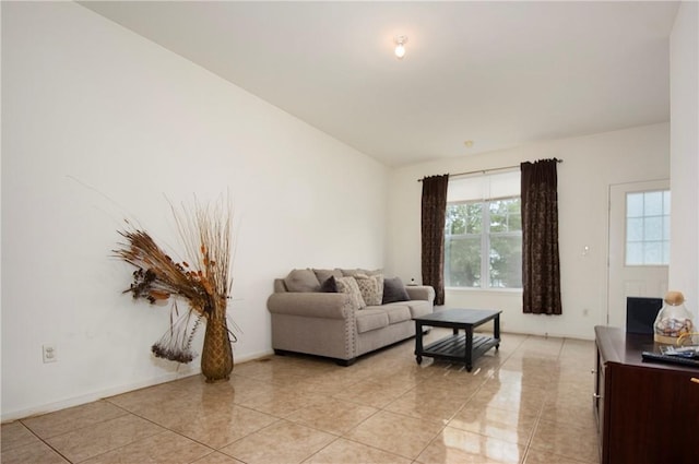 living room with light tile patterned floors and vaulted ceiling