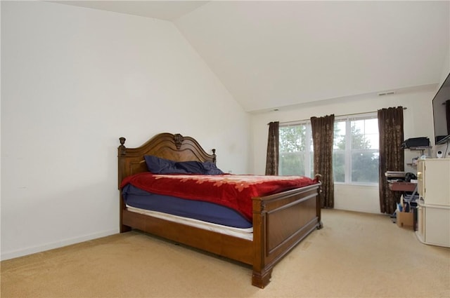 bedroom featuring light carpet and vaulted ceiling