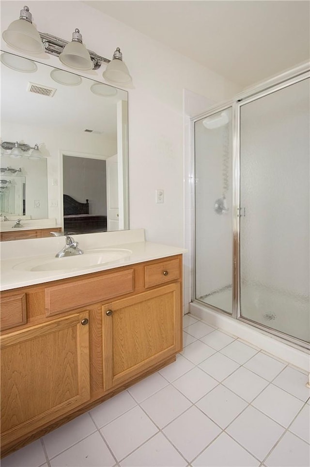 bathroom with tile patterned floors, vanity, and walk in shower