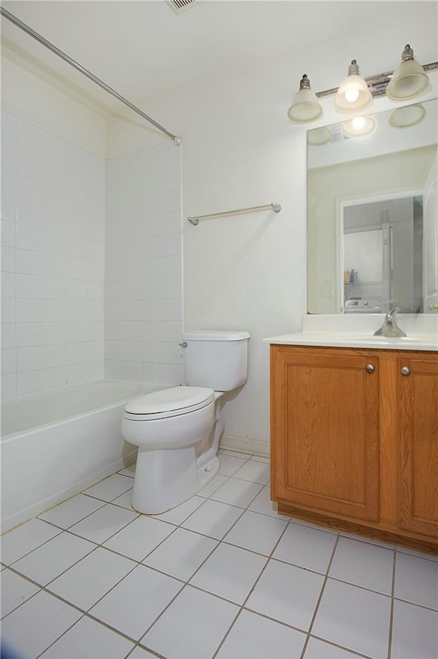 full bathroom featuring tiled shower / bath, tile patterned flooring, vanity, and toilet