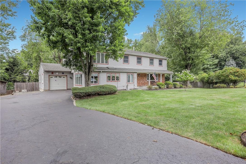 view of front of home featuring a garage, a front lawn, and an outdoor structure