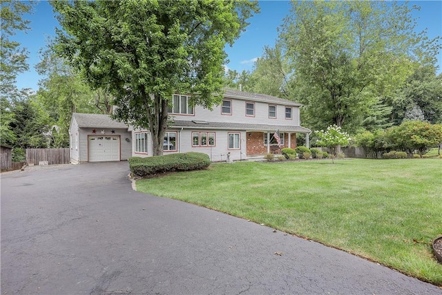 view of front of home featuring a garage, a front lawn, and an outdoor structure