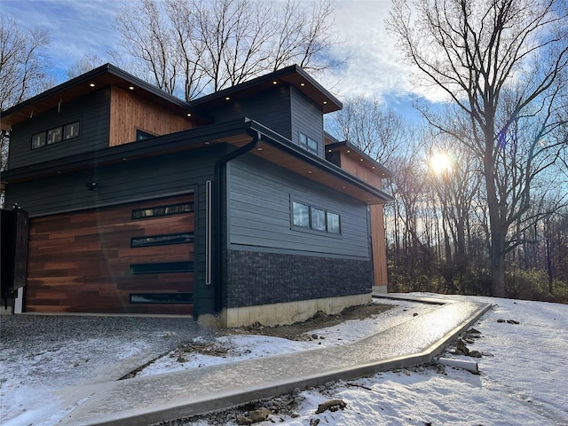 view of snowy exterior with a garage