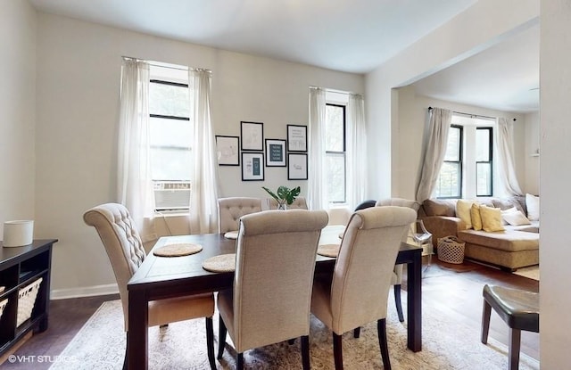 dining room featuring cooling unit, dark wood-type flooring, and a wealth of natural light