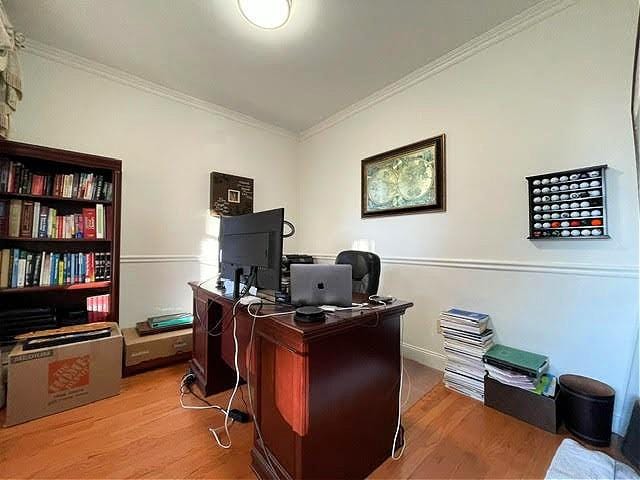 home office featuring light hardwood / wood-style floors and ornamental molding