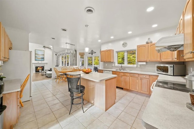 kitchen featuring white appliances, ceiling fan, light tile patterned floors, a kitchen island, and custom range hood