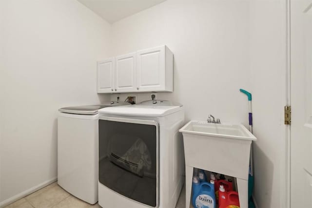 laundry room featuring cabinets, separate washer and dryer, and light tile patterned flooring