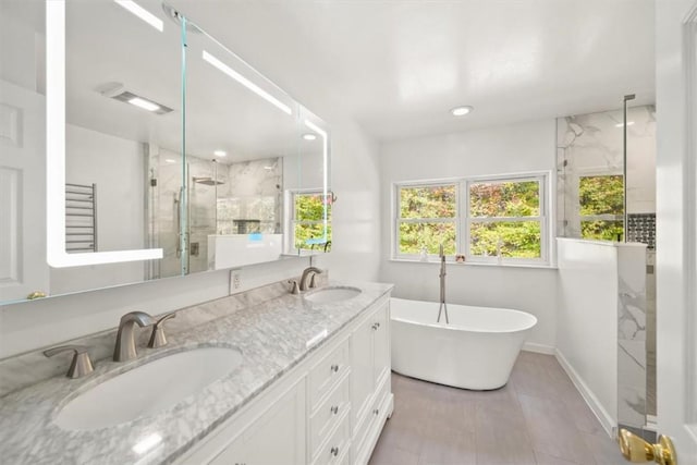 bathroom with vanity and shower with separate bathtub