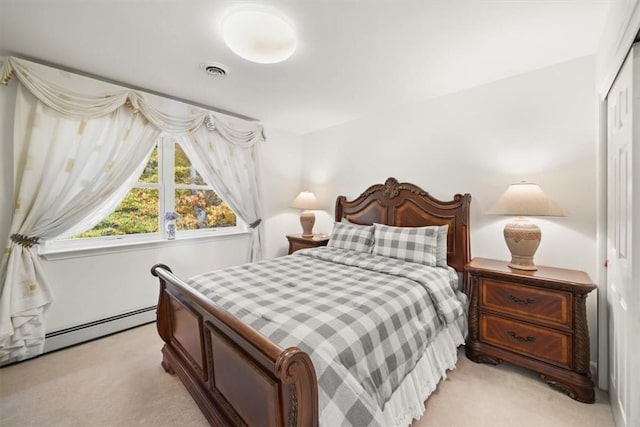 carpeted bedroom with baseboard heating and a closet