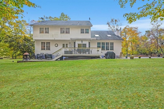 back of house featuring a deck and a lawn