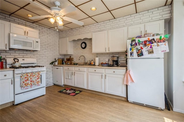 kitchen with light wood-type flooring, white appliances, white cabinetry, and a drop ceiling