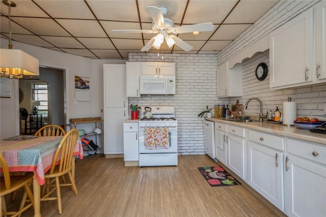 kitchen featuring white cabinetry, sink, and white appliances