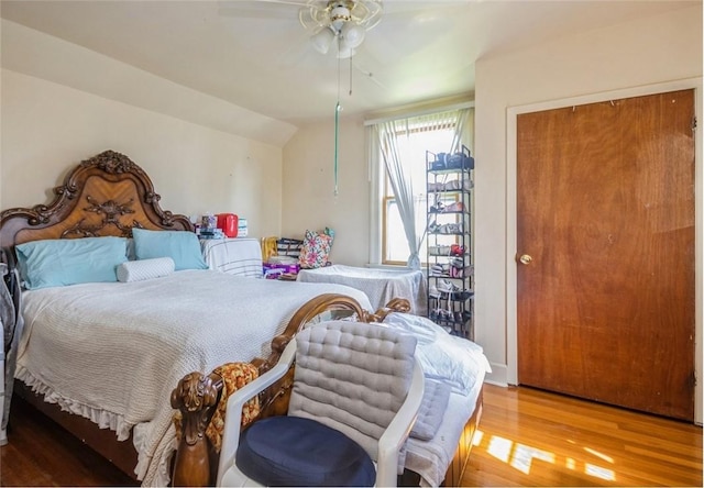 bedroom featuring ceiling fan, a closet, wood-type flooring, and lofted ceiling