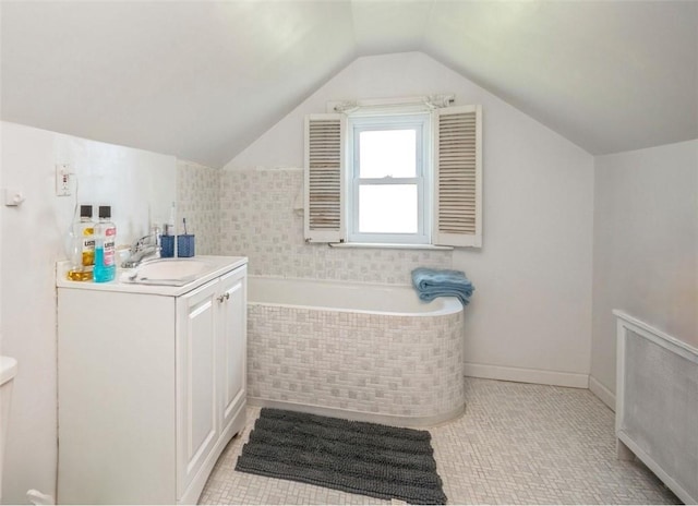 bathroom with a relaxing tiled tub, radiator heating unit, vanity, and vaulted ceiling