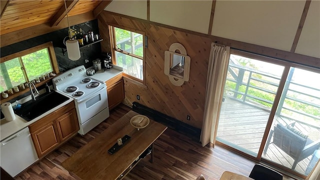 kitchen featuring white appliances, sink, wooden walls, vaulted ceiling with beams, and dark hardwood / wood-style flooring