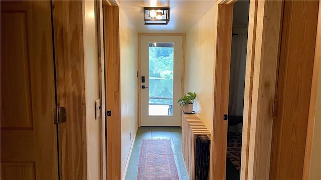 doorway featuring radiator heating unit, light tile patterned floors, and plenty of natural light