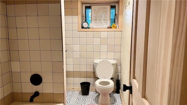 bathroom featuring tile patterned floors, toilet, and tile walls