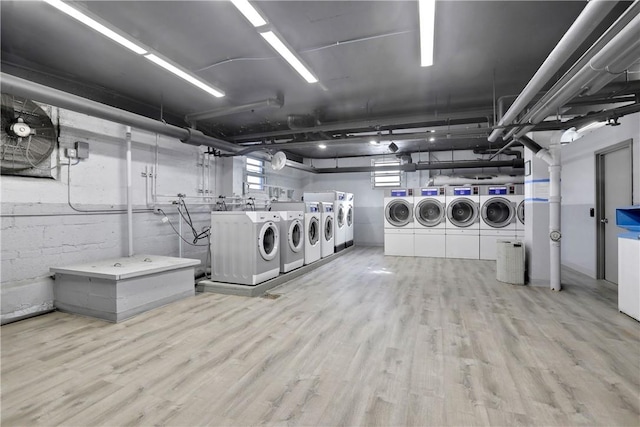 laundry area with washing machine and dryer and light wood-type flooring