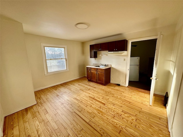 kitchen with white fridge, sink, and light hardwood / wood-style flooring